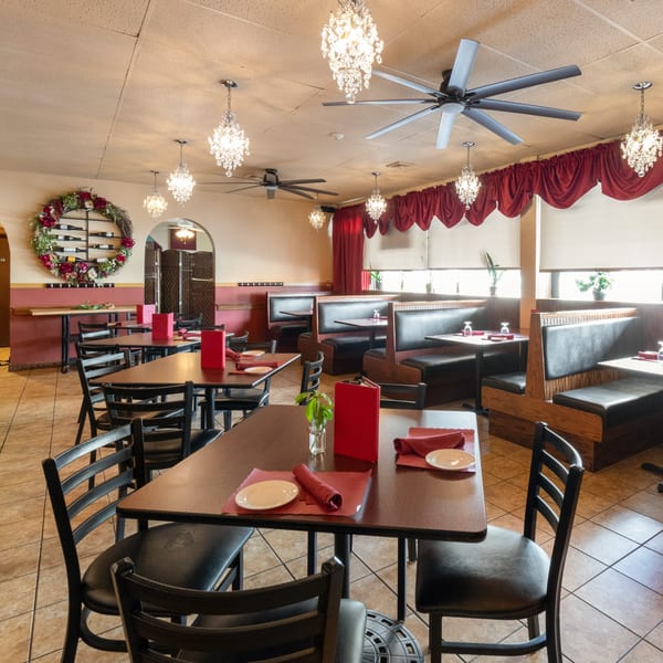 Dining room at Sorrento Restaurant with tables, chairs, booths, chandeliers, and a wine rack.